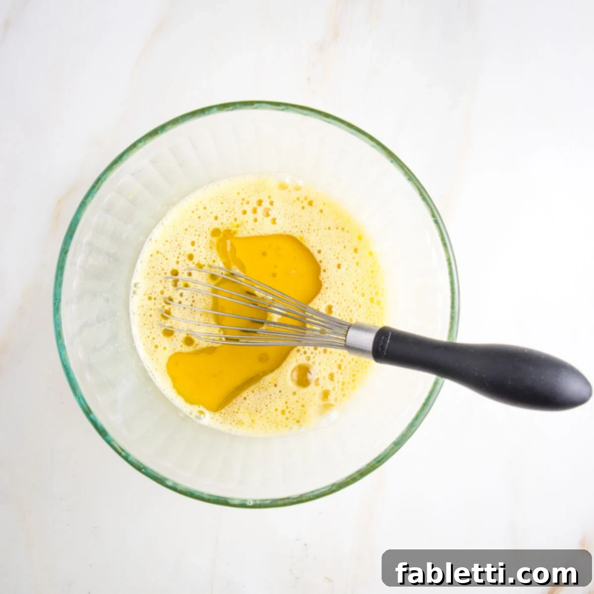 Whisking eggs in a glass bowl.