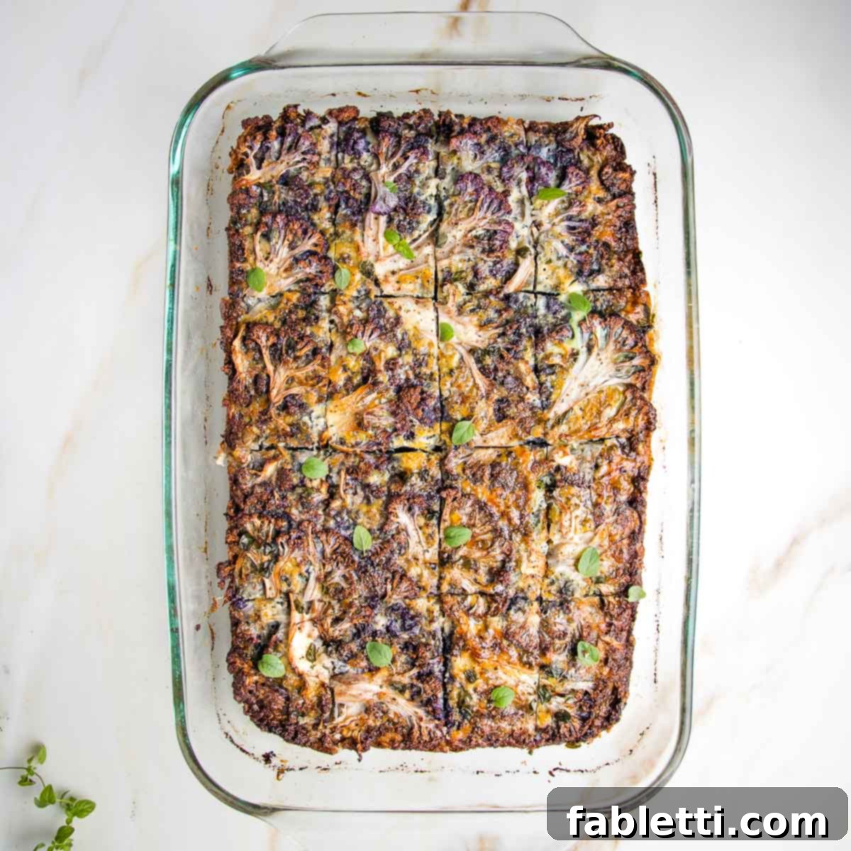 Cauliflower kugel in glass baking dish cut into squares.