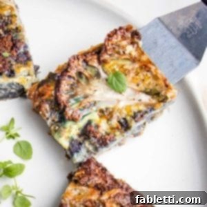 Small spatula placing a slice of cauliflower kugel onto a white rimmed plate with other pieces of kuel already on it. The kugel has a thin slice of cauliflower on the top of the piece along with a fresh oregano leaf.