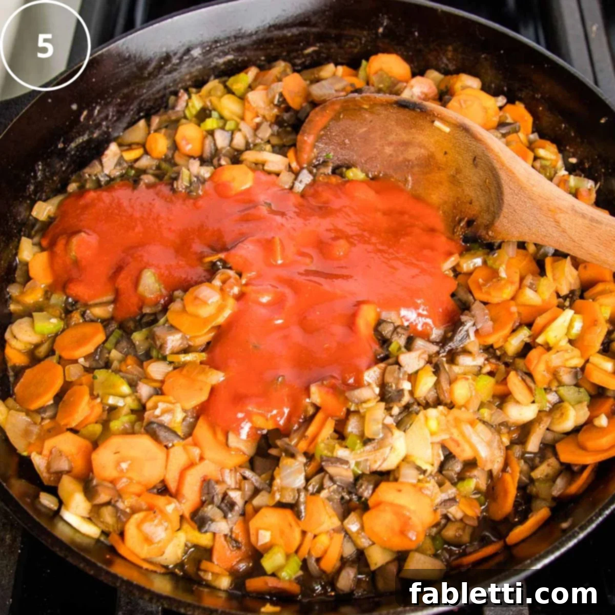 Sun-Kissed Vegan Shepherd's Pie 15 Sauteed veggies in a cast iron skillet with tomato sauce poured over the top.