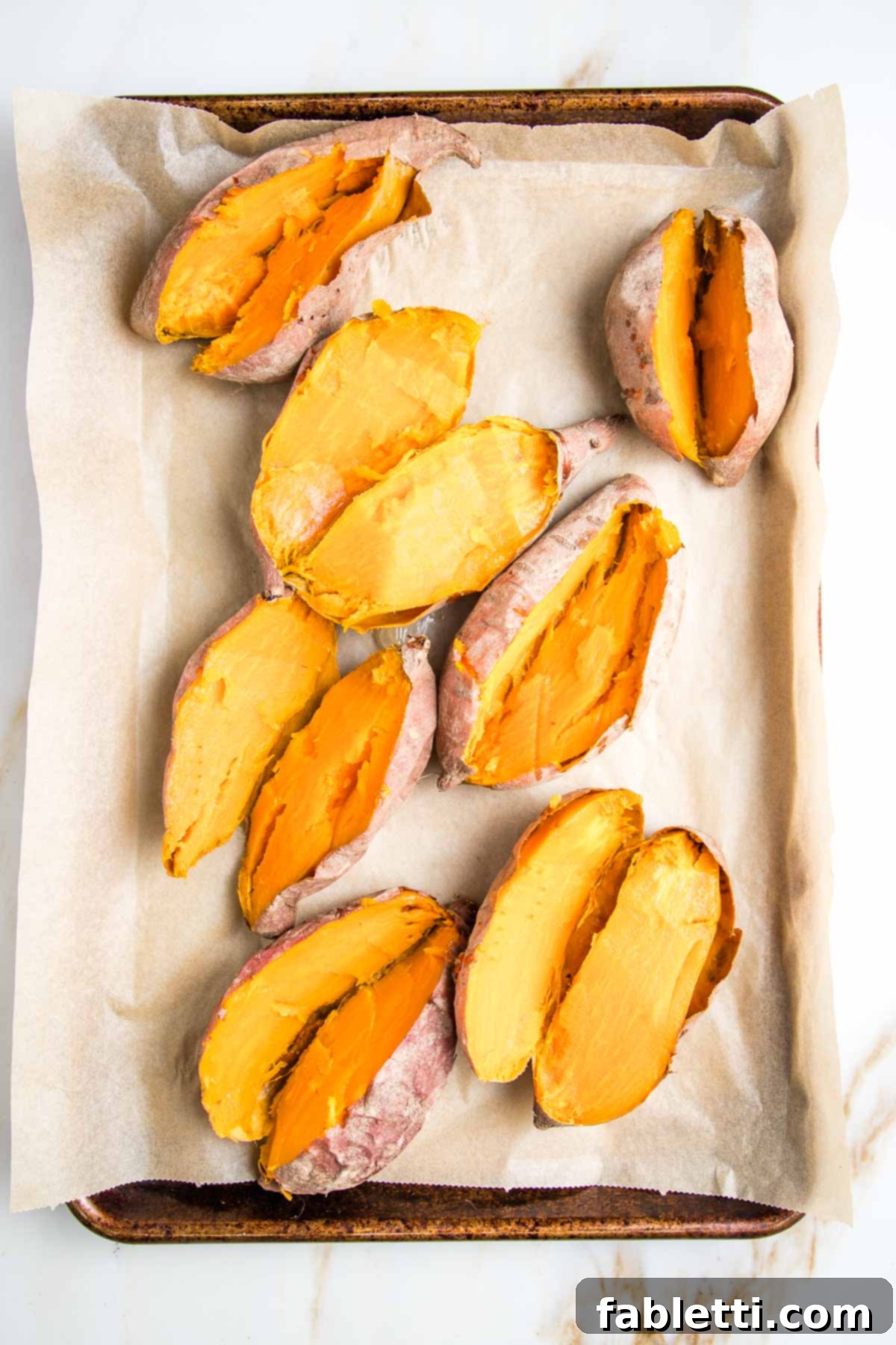 Sun-Kissed Vegan Shepherd's Pie 7 Baked sweet potatoes that have been cut in half to expose their orange flesh.