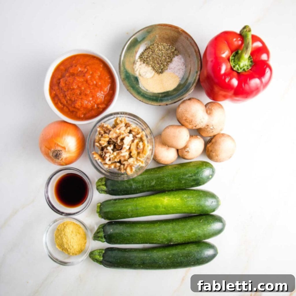 Satisfying Plant-Powered Zucchini Boats 3 A vibrant selection of ingredients for stuffed zucchini: red bell pepper, mushrooms, fresh zucchini, marinara sauce, walnuts, a blend of spices, onion, tamari, and nutritional yeast, all ready for preparation.