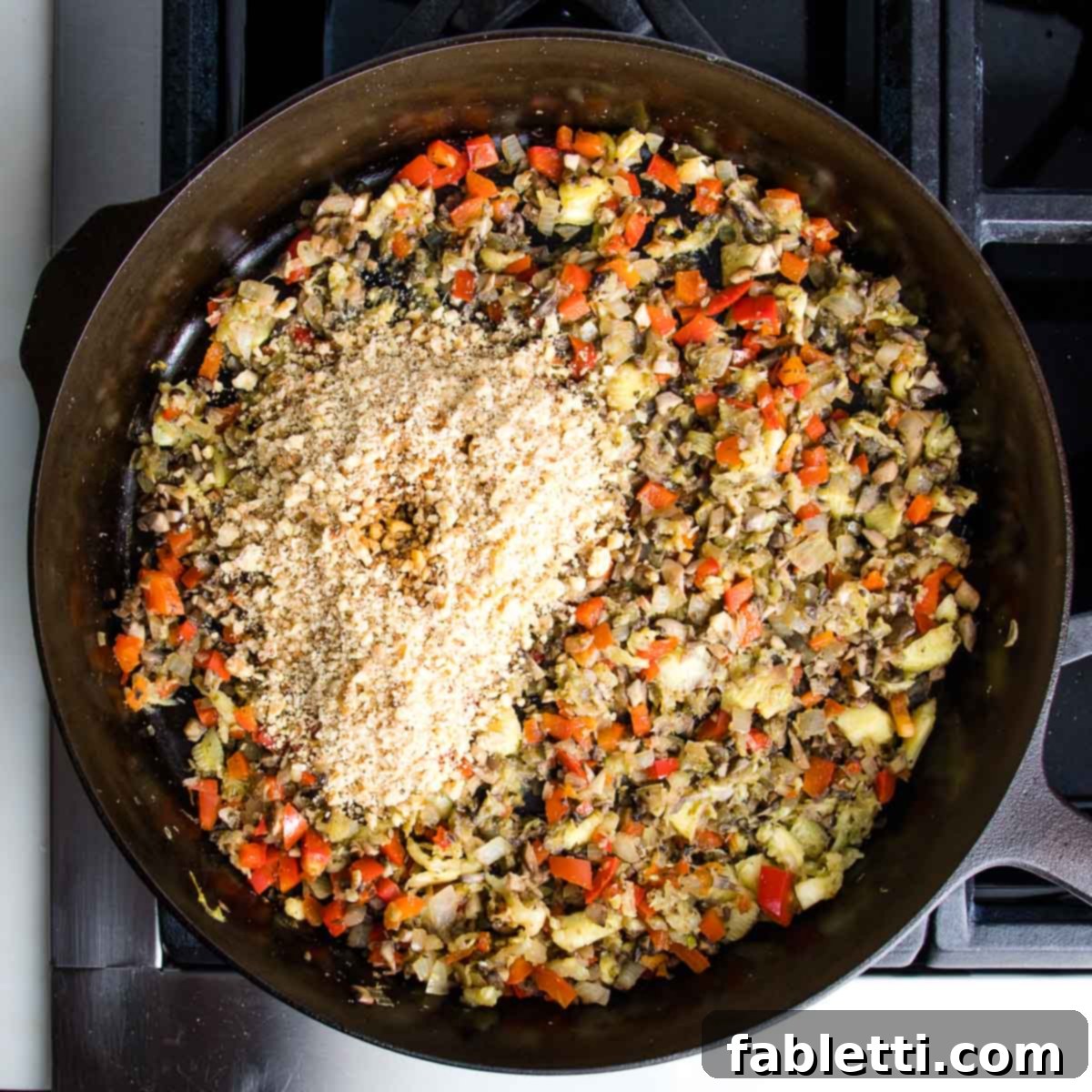 Satisfying Plant-Powered Zucchini Boats 10 The savory filling mixture in the skillet, now perfectly cooked, has the finely chopped walnuts and tamari added. The ingredients are waiting to be thoroughly combined for the next stage of preparation.