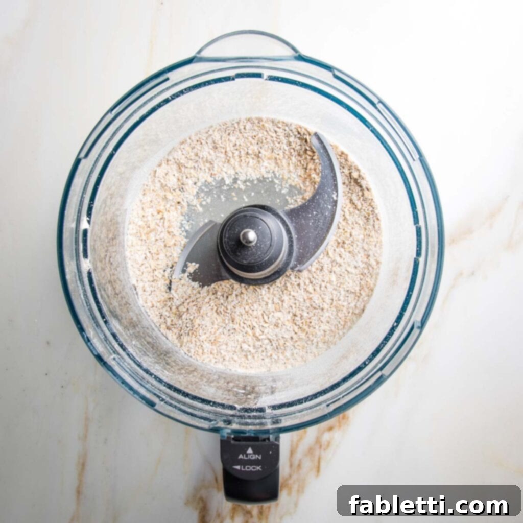 Irresistible Cookie Dough Poppers 5 Ground oats in a food processor bowl.