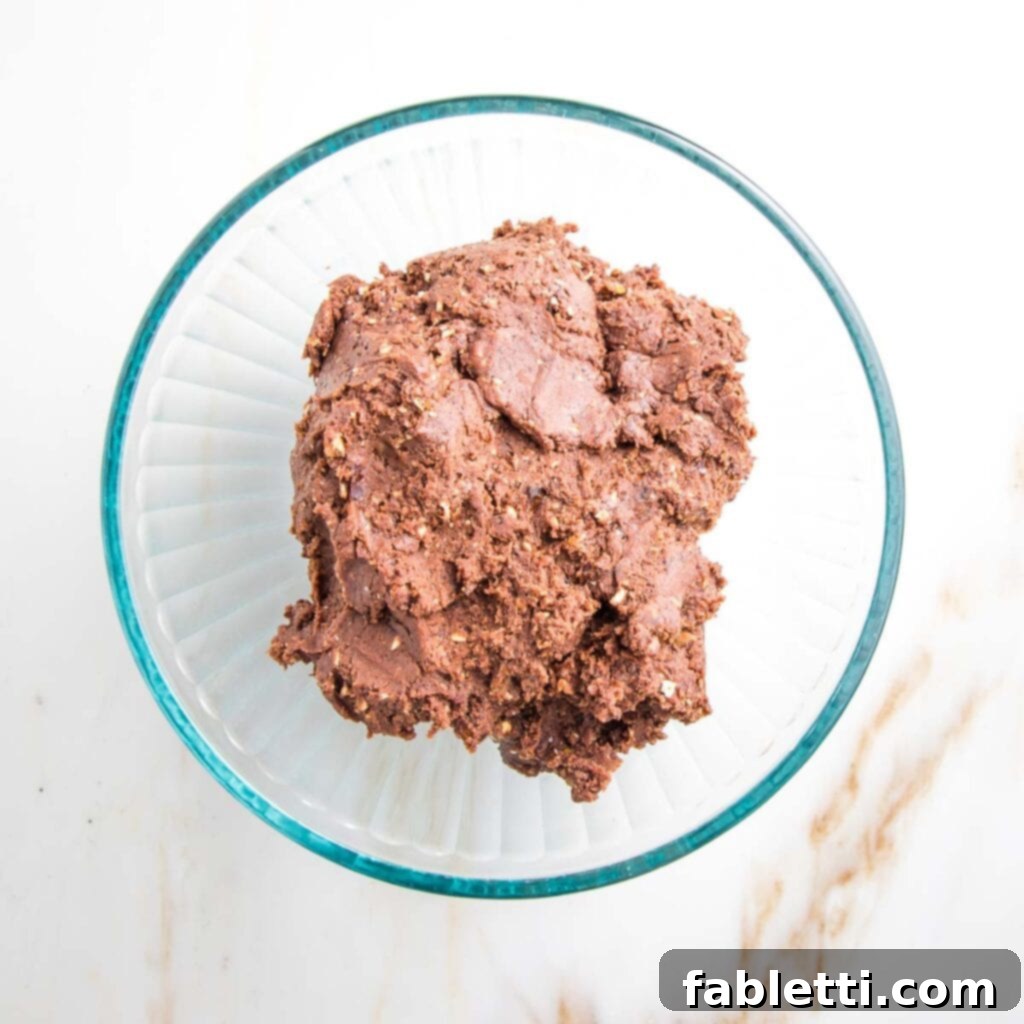 Irresistible Cookie Dough Poppers 8 Raw chocolate cookie dough in a glass bowl.