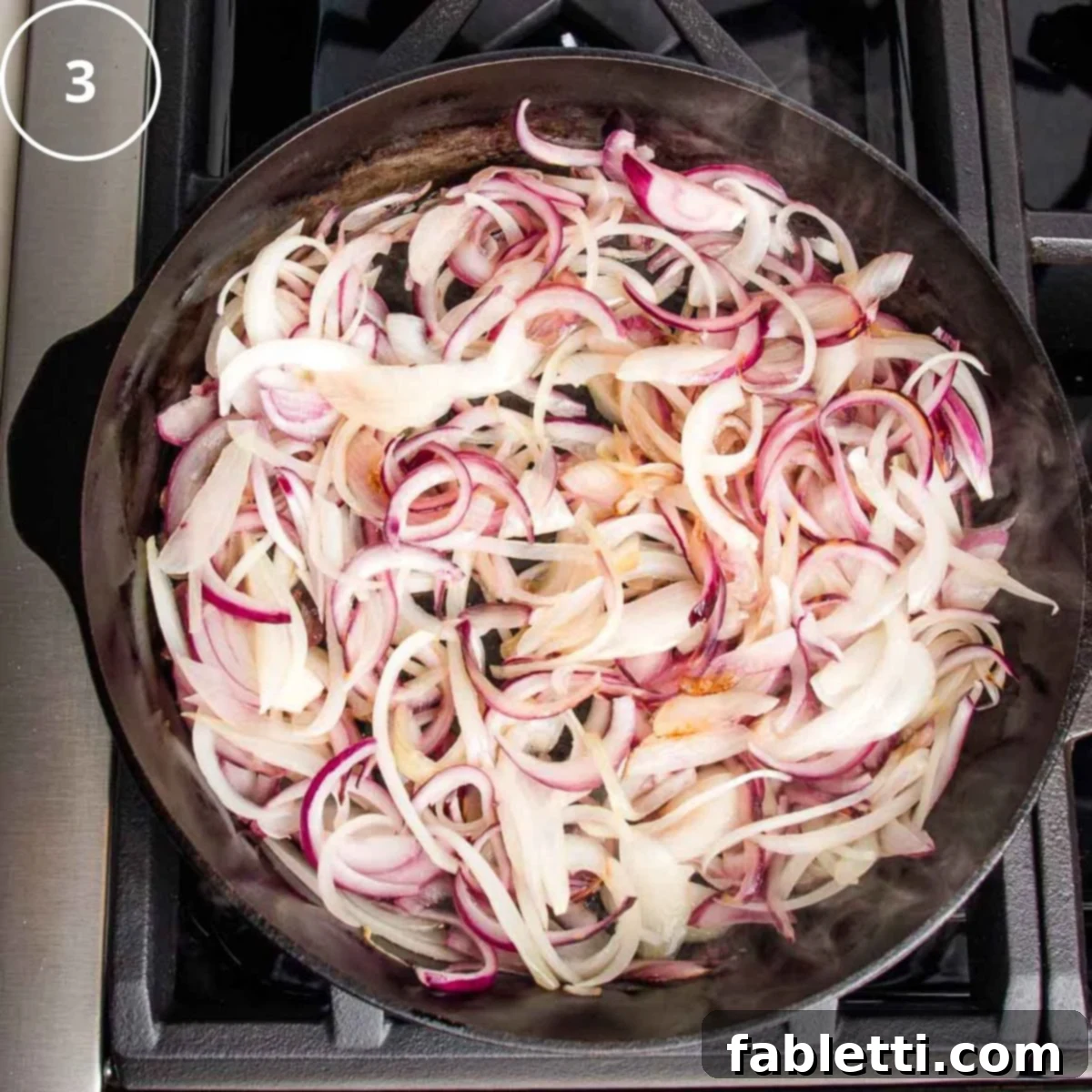 Sliced purple onions in a cast iron skillet.