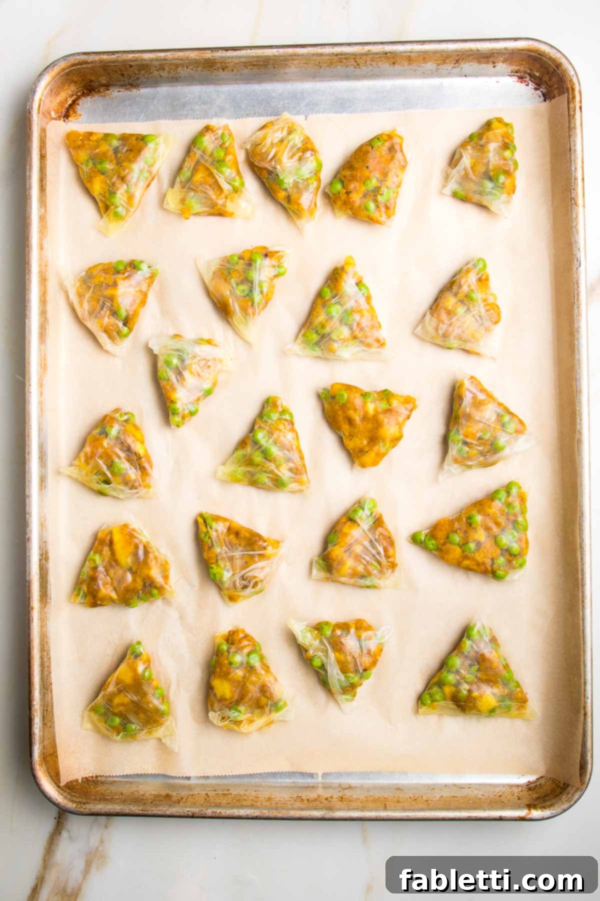 Crispy Baked Samosas with Zesty Cilantro Chutney 15 Triangle samosas in rice paper, filled with peas and potatoes, ready to bake.
