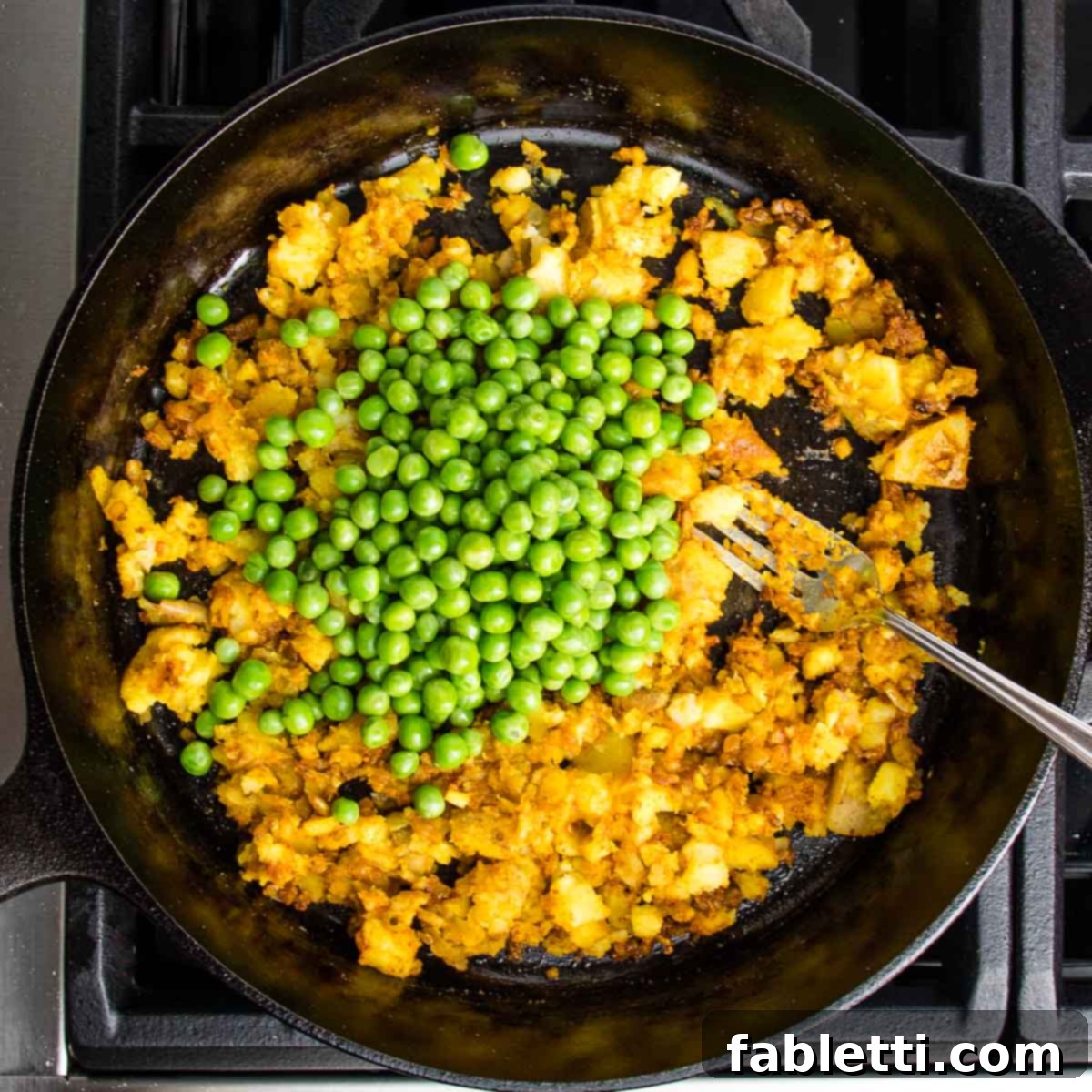 Crispy Baked Samosas with Zesty Cilantro Chutney 7 cast iron skillet filled with sauteed potatoes, onions and spices and a cup of peas on top