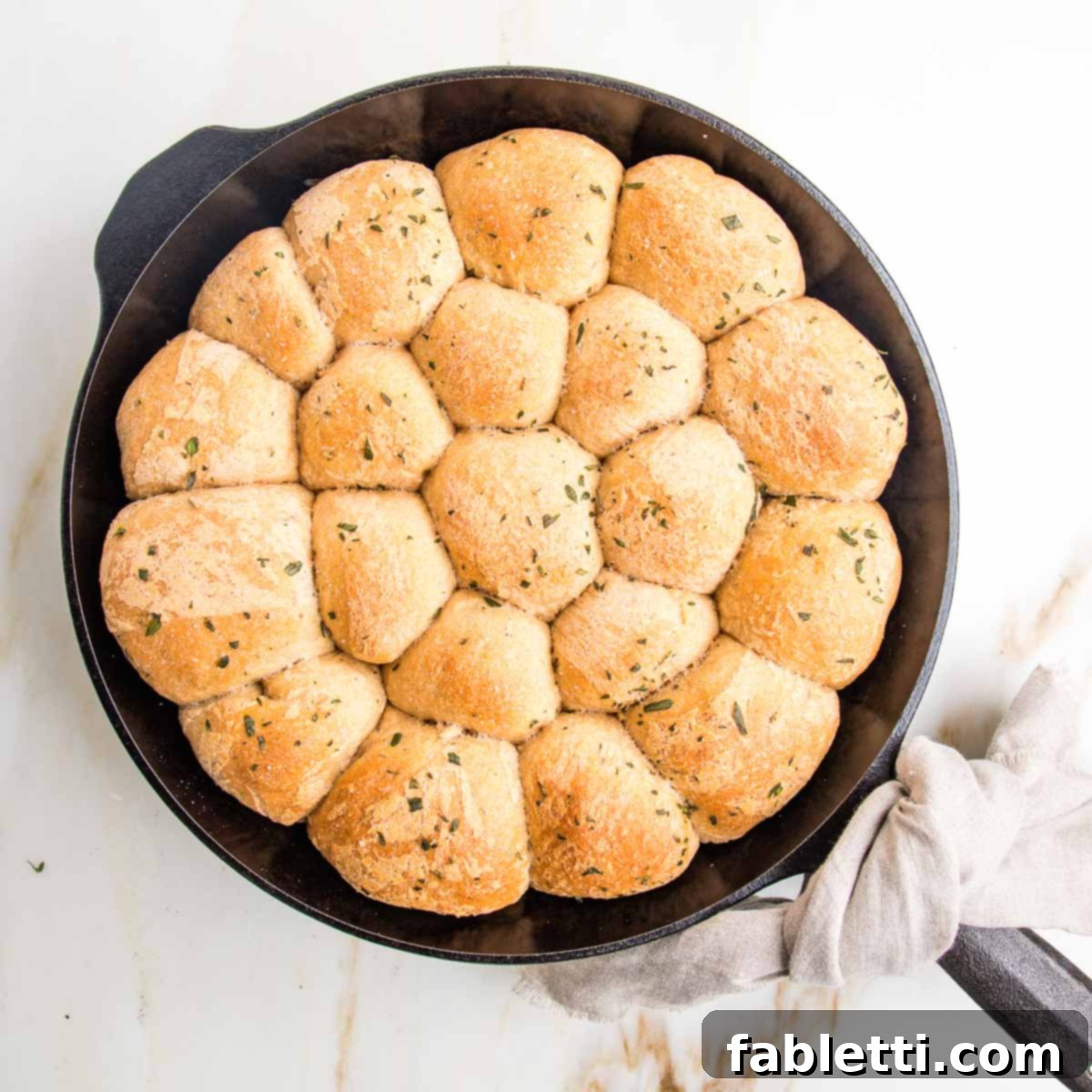 Fluffy Vegan Dinner Rolls 2 Skillet with herby dinner rolls packed in tightly.