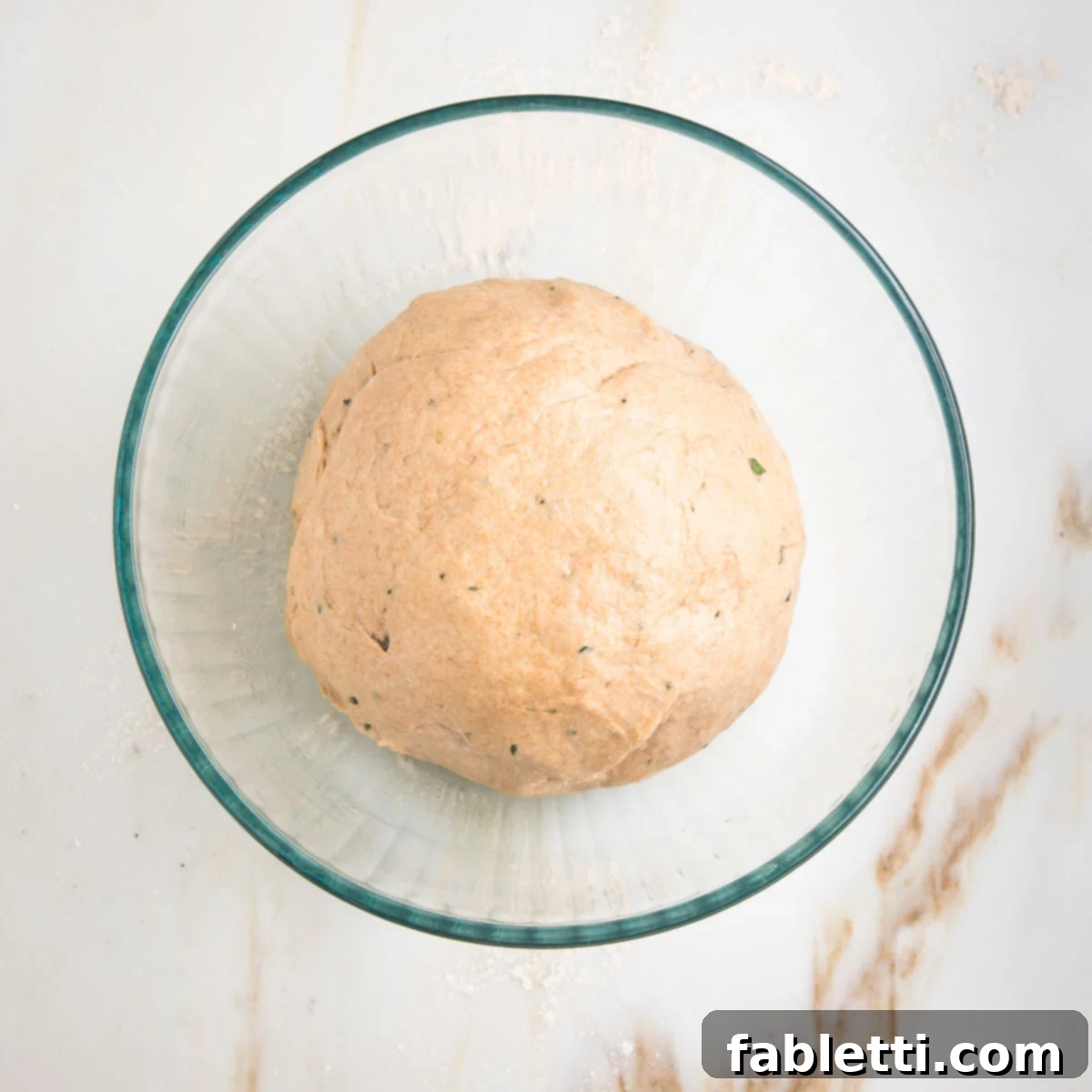 Fluffy Vegan Dinner Rolls 14 ball of dough with light sheen from oil inside of a glass bowl