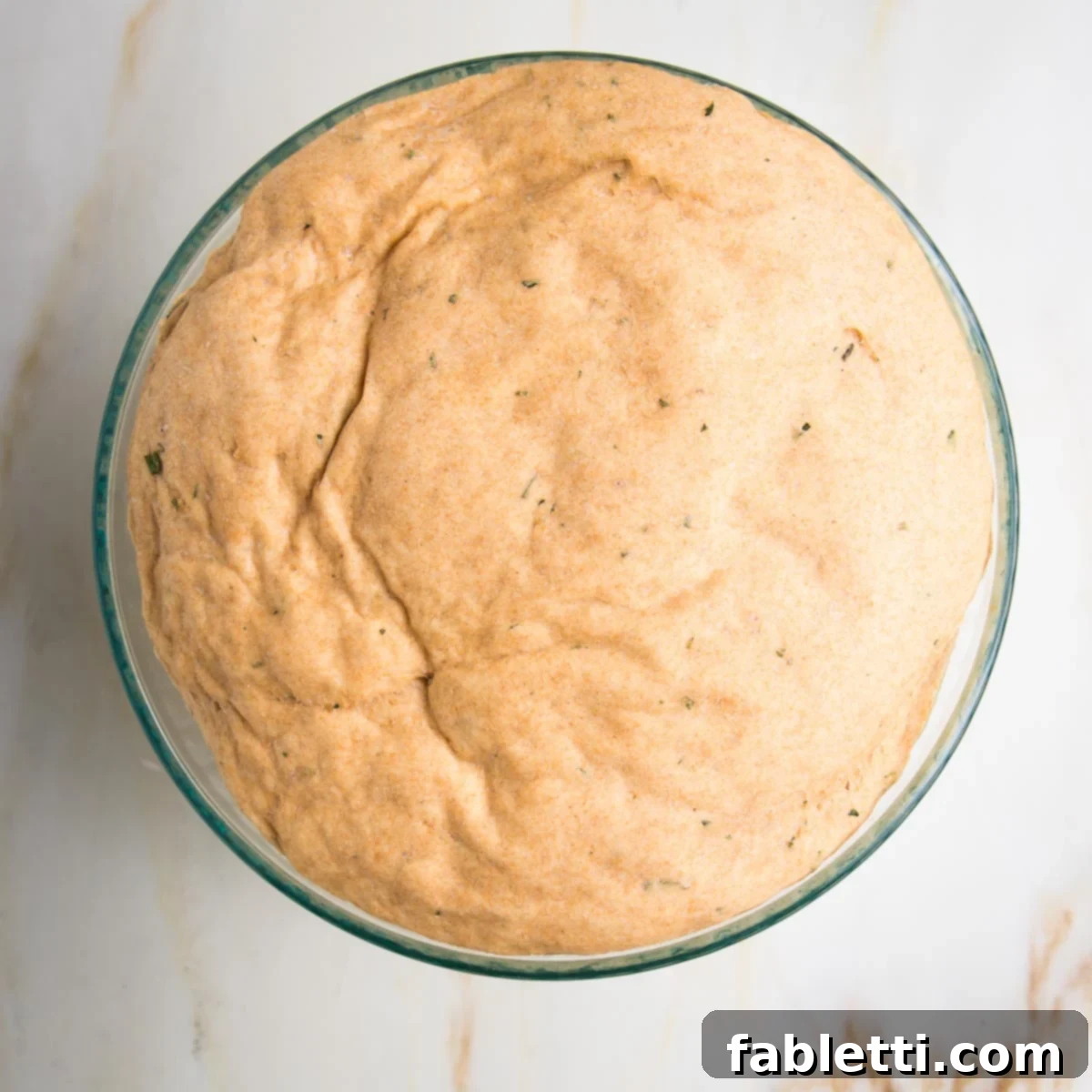 Fluffy Vegan Dinner Rolls 15 Dough in a glass bowl that has risen to take up the entire bowl.