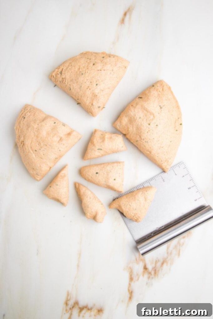 Fluffy Vegan Dinner Rolls 16 Ball of dough cut into quarters and then one of the quarters is cut into 5 equal portions.