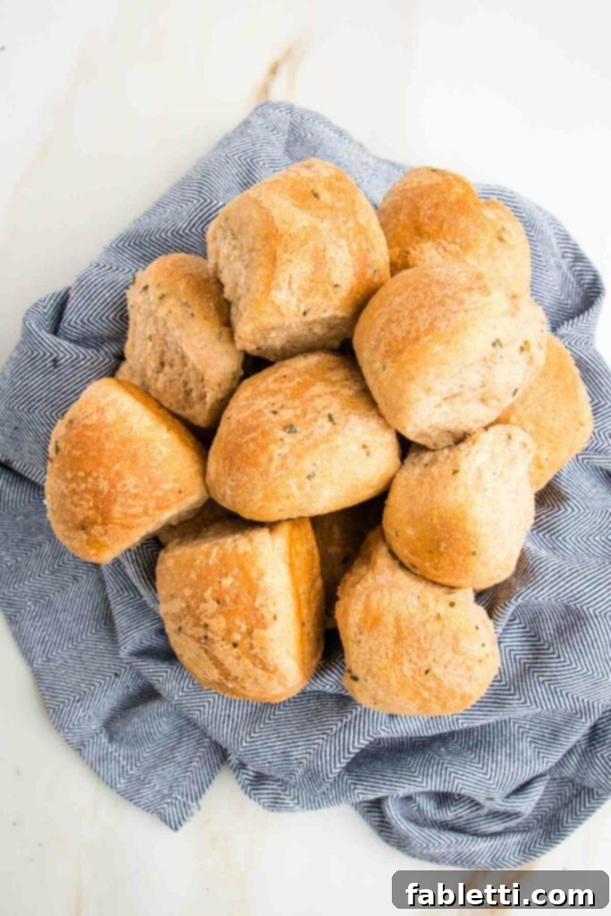 Fluffy Vegan Dinner Rolls 19 Blue dish towel inside a bowl and filled with herby dinner rolls.