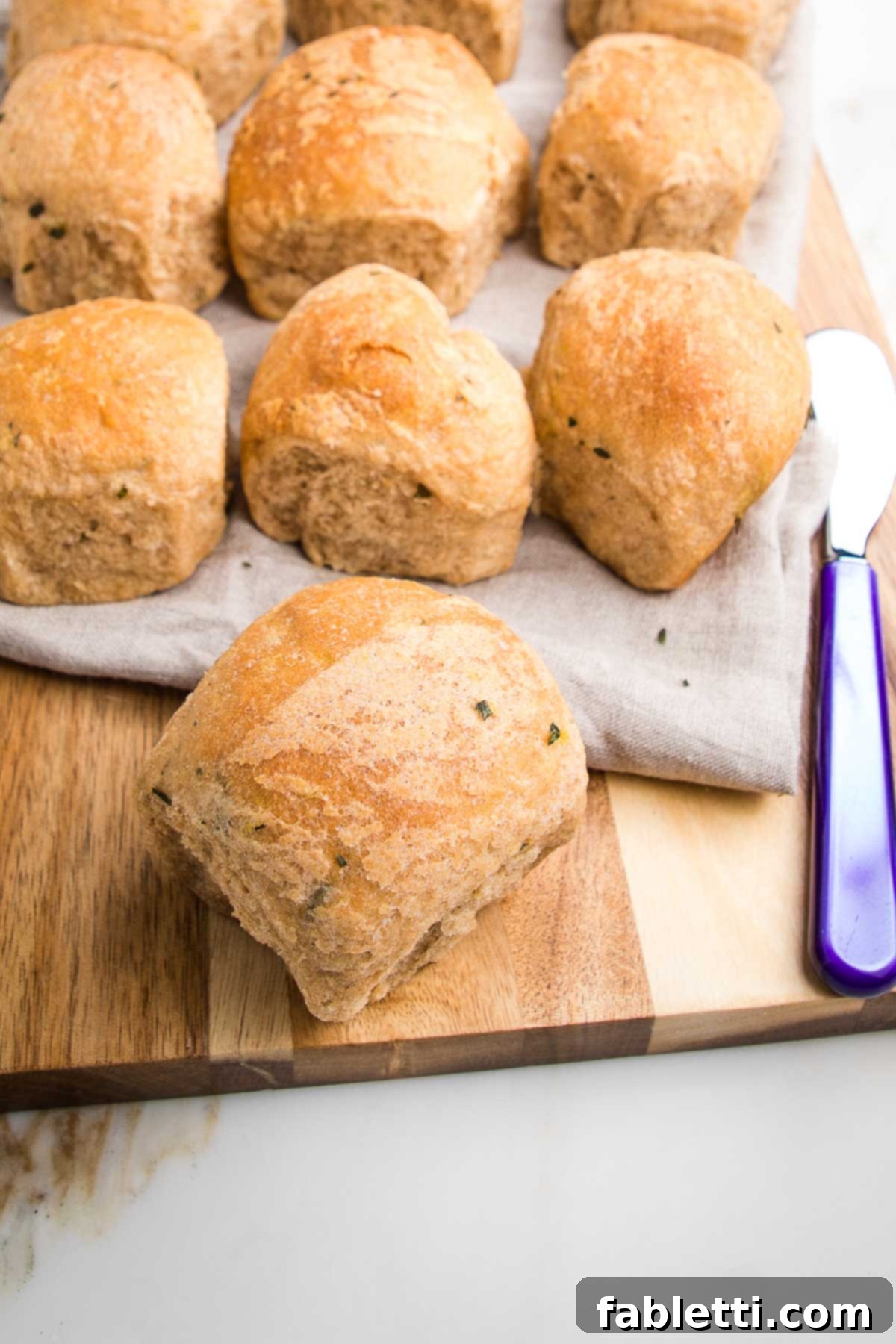 Fluffy Vegan Dinner Rolls 20 Row of dinner rolls with one close up.