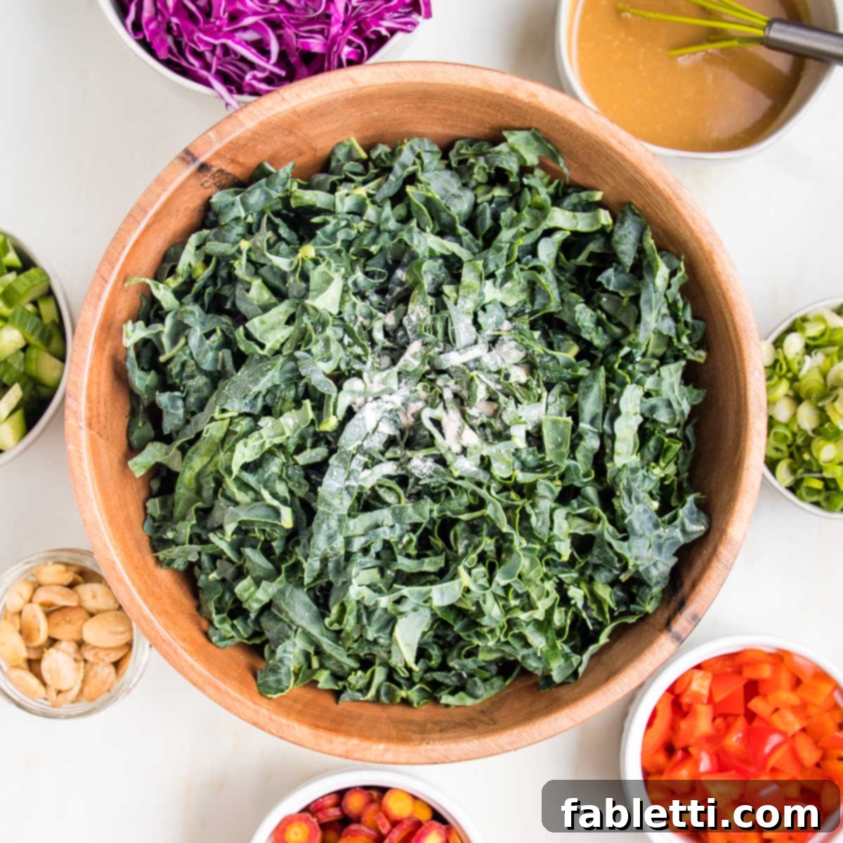 Rustic Tuscan Chopped Kale Medley 6 Thinly sliced tuscan kale with small bowls of colorful ingredients all around the bowl of kale.