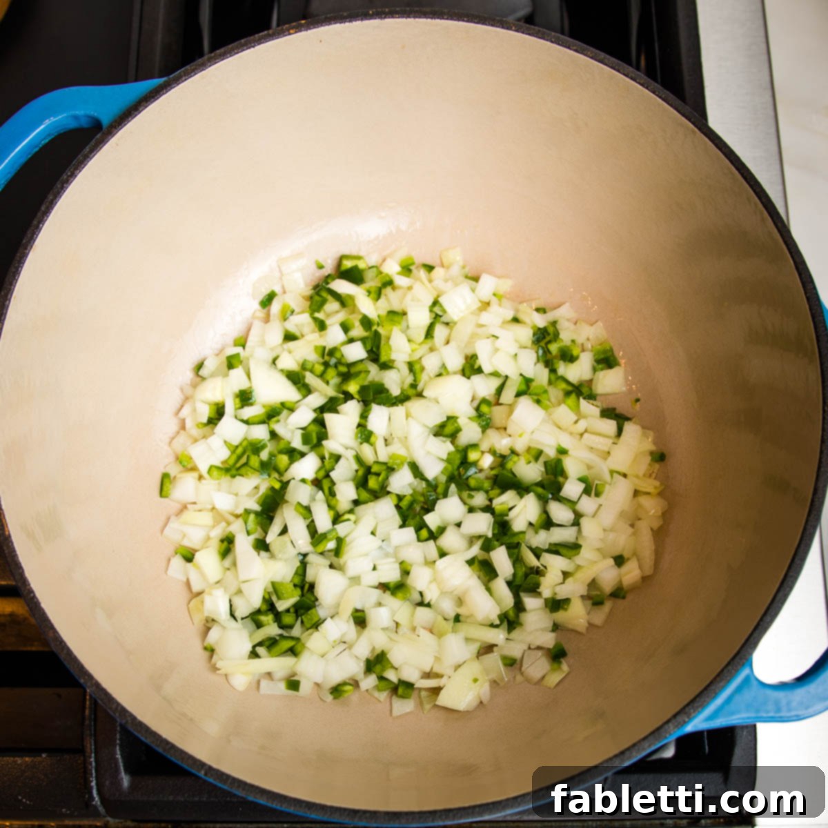 Hearty Vegan Taco Soup with Crispy Tortilla Strips 11 blue dutch oven with jalapenos and onions sauteeing