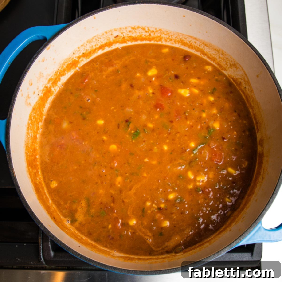 Hearty Vegan Taco Soup with Crispy Tortilla Strips 16 Blue dutch oven filled with taco soup. on the stove.
