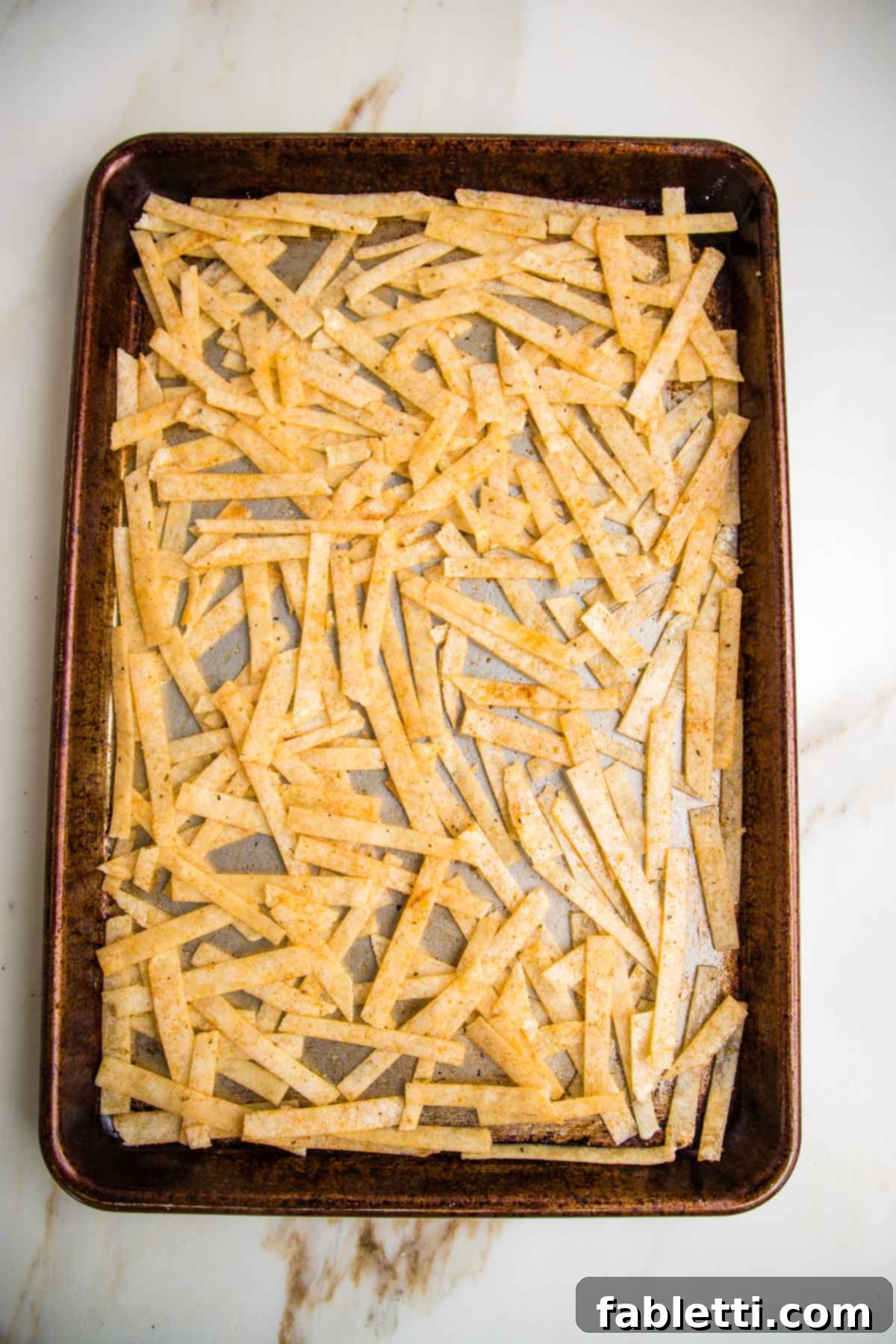 Hearty Vegan Taco Soup with Crispy Tortilla Strips 8 Rimmed baking tray with tortillas cut into strips and coated with taco seasonings