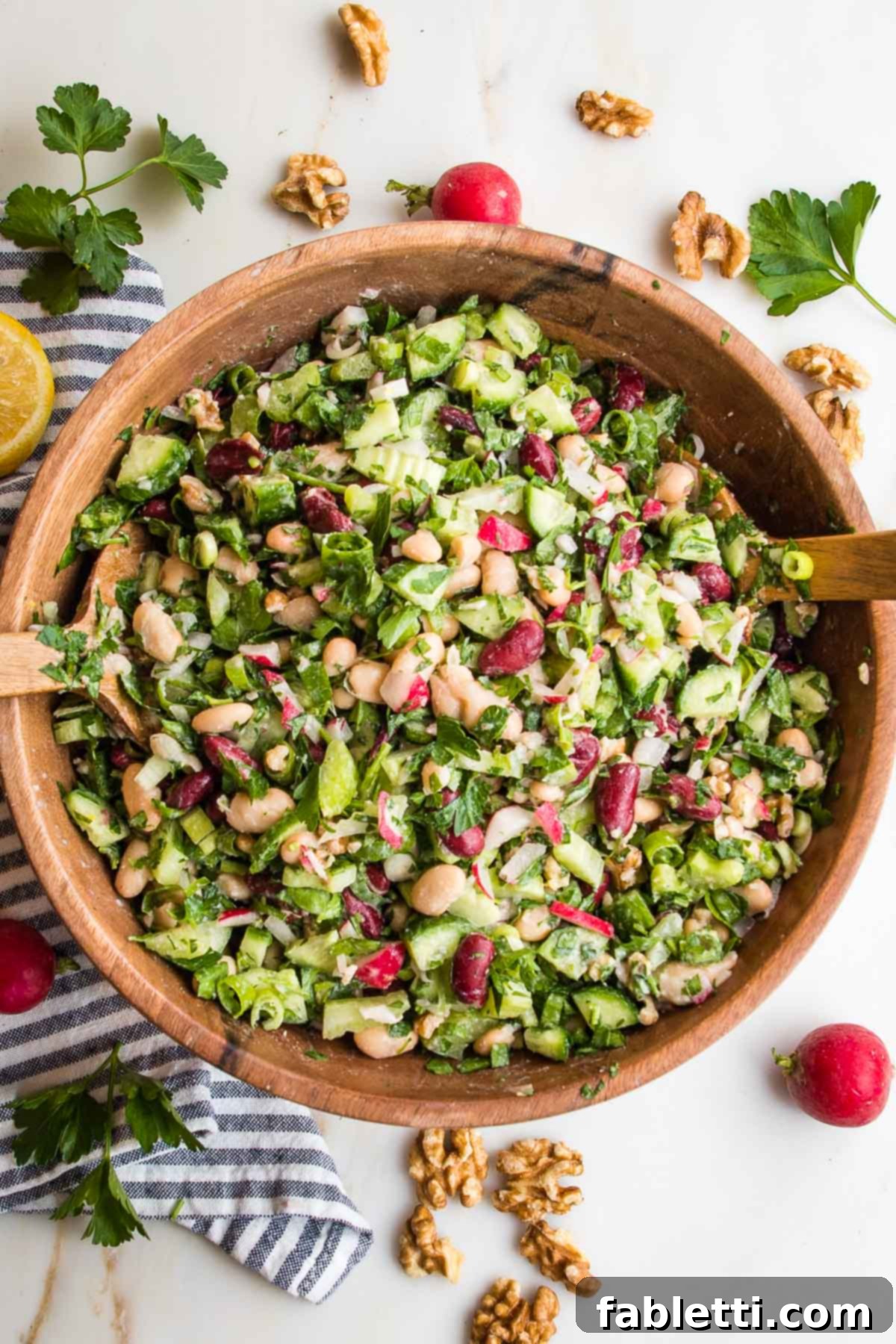 Zesty Kidney Bean Salad 10 Large wooden bowl filled with bean salad: chopped radish, white and red beans, chopped parsley, cucumbers, celery and scallions.