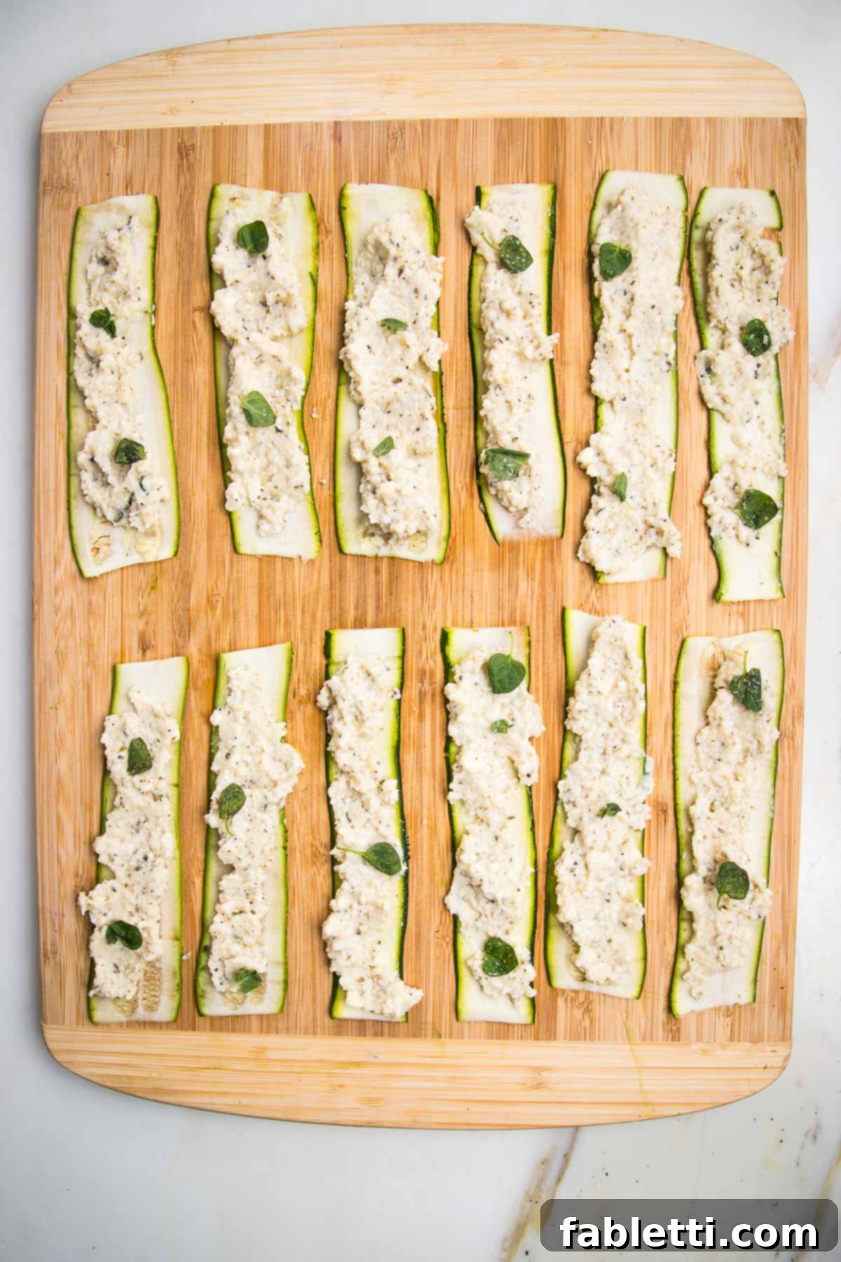 Plant-Based Zucchini Ricotta Rolls 9 Zucchini strips, spread with vegan ricotta and sprinkled with fresh oregano.