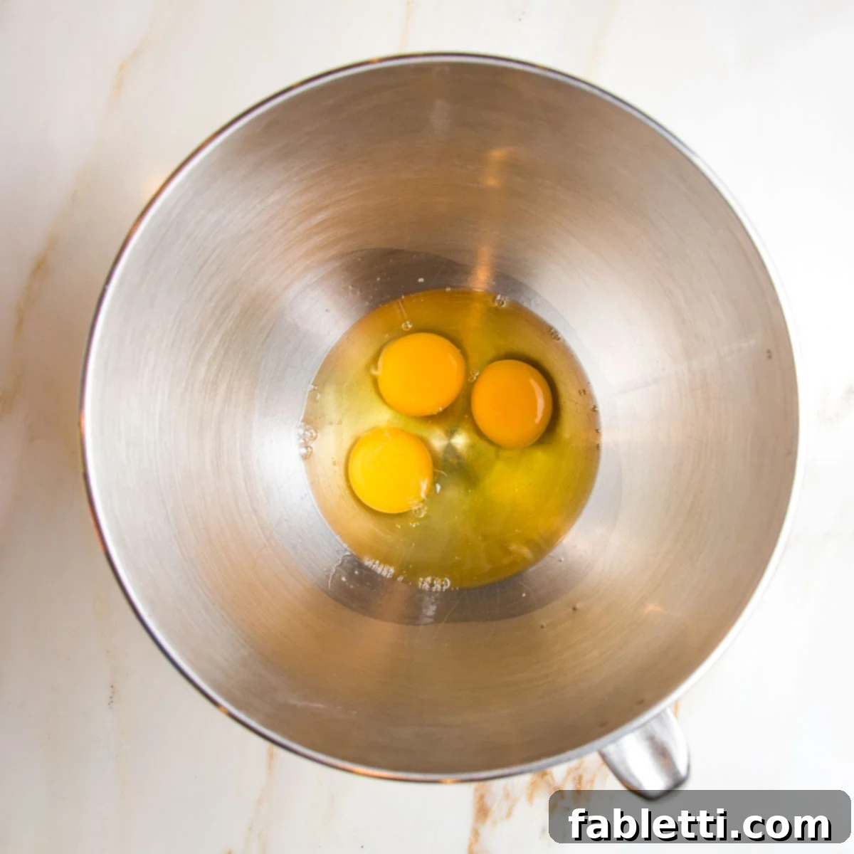 Wet ingredients for lemon cake: eggs, olive oil, honey, lemon juice.