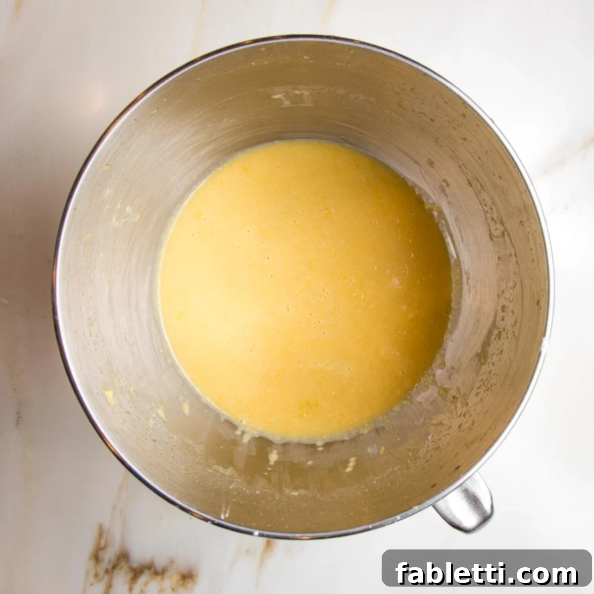 Mixed cake batter, bright yellow and thickening.