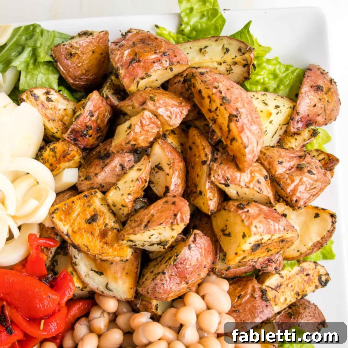 Vibrant Vegan Nicoise 3 close up of a portion of plattered nicoise salad showing the roasted herby potatoes.