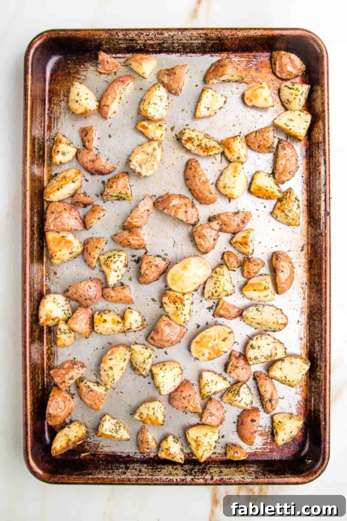 Vibrant Vegan Nicoise 6 rimmed baking tray with potatoes cut into halves and quarters, roasted with herbs