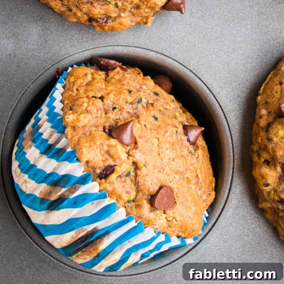 Garden Fresh Vegan Zucchini Muffins 4 Chocolate Chip Zucchini Muffin inside the muffin tin, turned on its side so you can see the pretty striped blue wrapper.