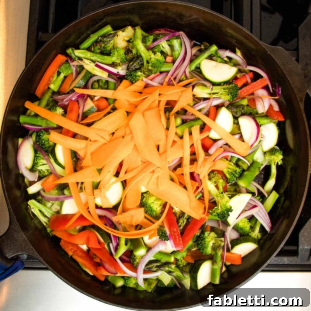 Vibrant Vegan Primavera Pasta 11 Zucchini half moons and red bell pepper strips added to the skillet, tossed with other vegetables.