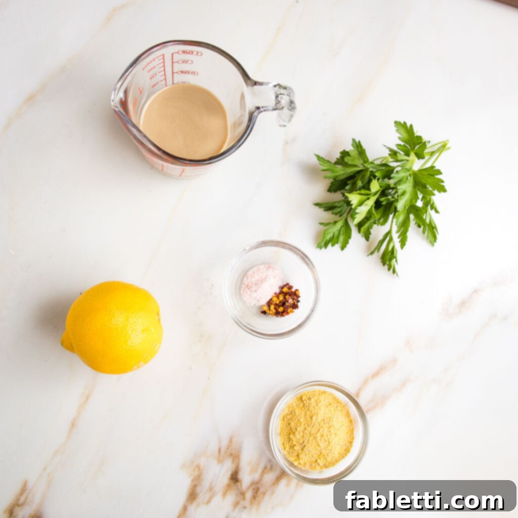 Vibrant Vegan Primavera Pasta 4 Ingredients laid out for pasta sauce: tahini, lemon, salt, pepper, nutritional yeast, fresh parsley