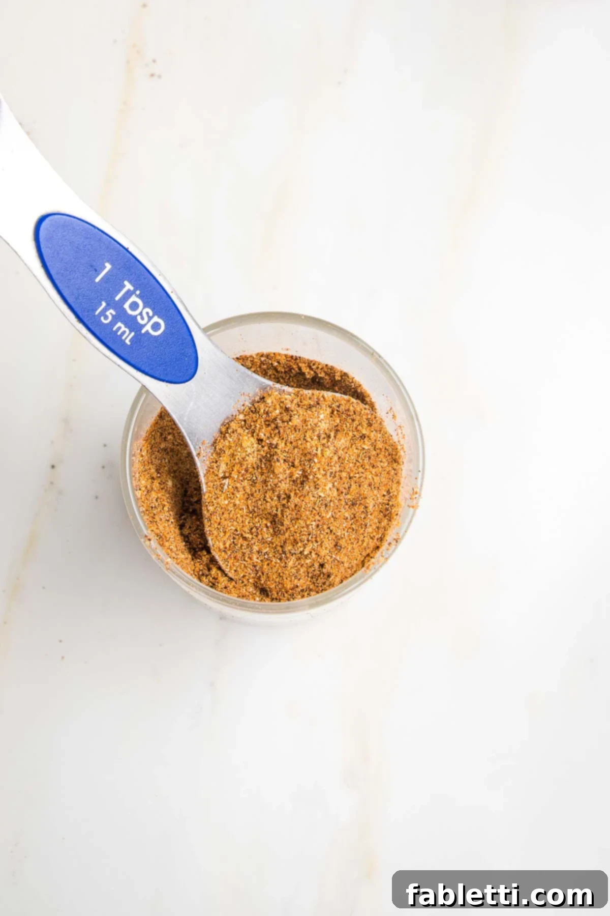 Salt-Free Homemade Taco Seasoning 6 Small glass jar of taco seasoning with a 1 Tablespoon measuring spoon scooping some out of the jar.