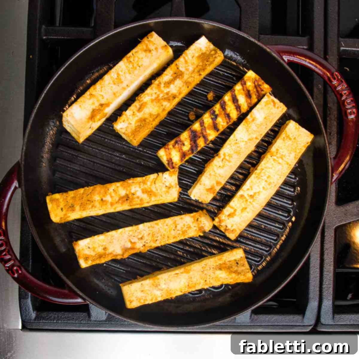 Grilled Tofu Satay with Creamy Peanut Sauce 14 Round grill pan with tofu satay sticks. One has been flipped to show grill marks.