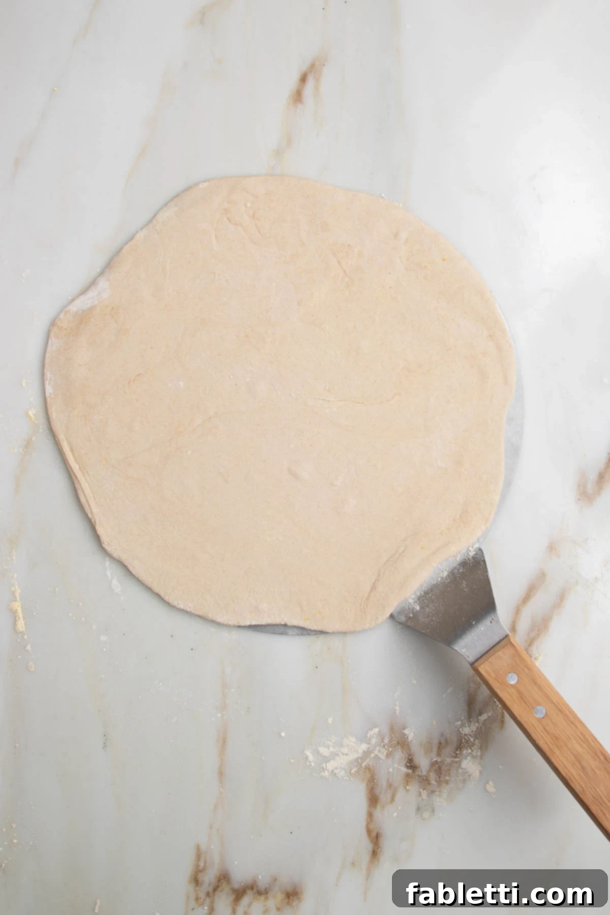 Effortless Yeast-Free Flatbread Pizza 11 Flatbread pizza dough gently resting on a pizza peel, ready for transfer to the hot oven, highlighting preparation ease.