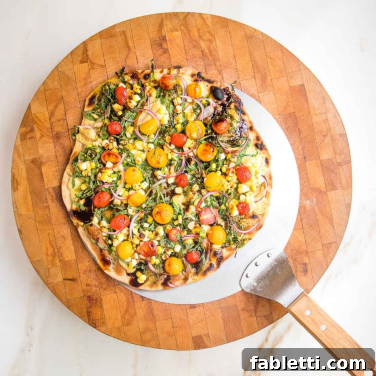 Effortless Yeast-Free Flatbread Pizza 17 A pizza peel gracefully delivering a beautifully topped flatbread with colorful vegetables onto a rustic wooden cutting board, ready for slicing.