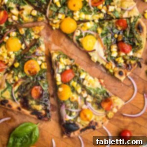 Effortless Yeast-Free Flatbread Pizza 21 Flatbread Pizza with pesto, hummus, yellow and red tomatoes plus fresh basil and red onions. One slice shown up close and a few others partially shown on a wooden cutting board, invitingly presented.