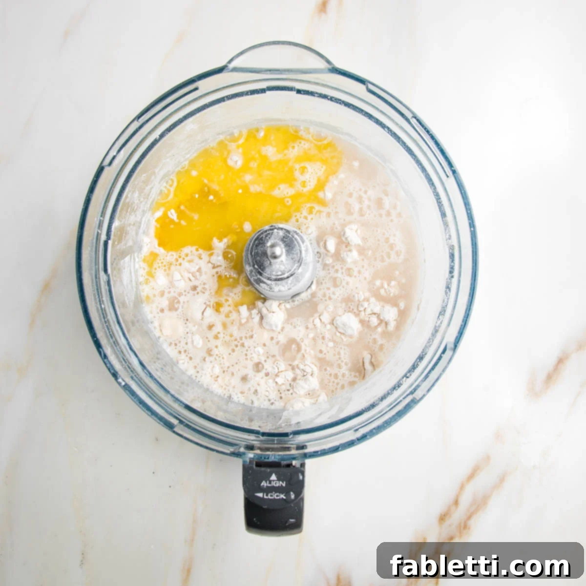 Effortless Yeast-Free Flatbread Pizza 5 Flour, salt, oil and water in the bowl of a food processor, ready for mixing to create the flatbread dough.