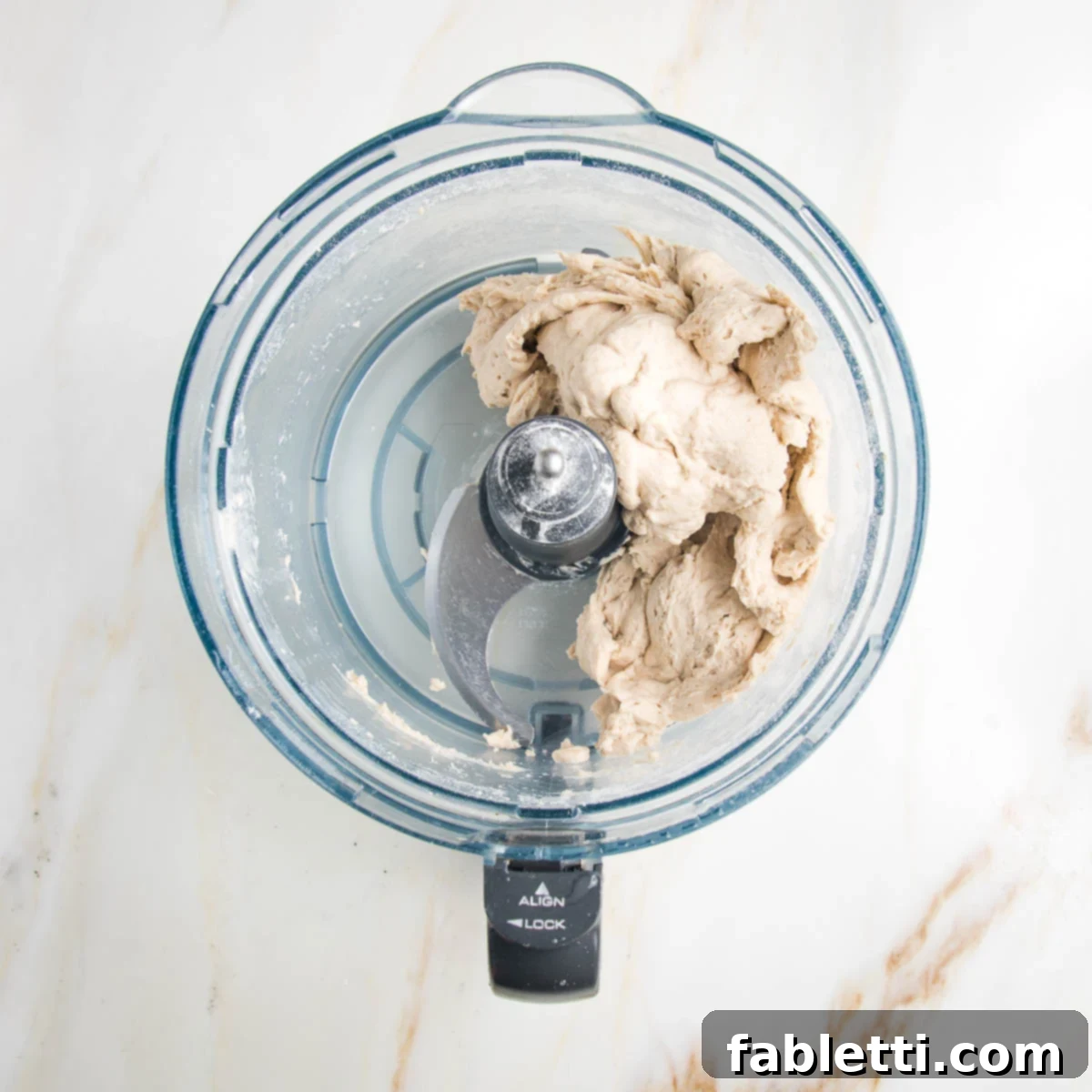 Effortless Yeast-Free Flatbread Pizza 6 No yeast flatbread dough roughly mixed in the bowl of a food processor, showing its initial cohesive texture.