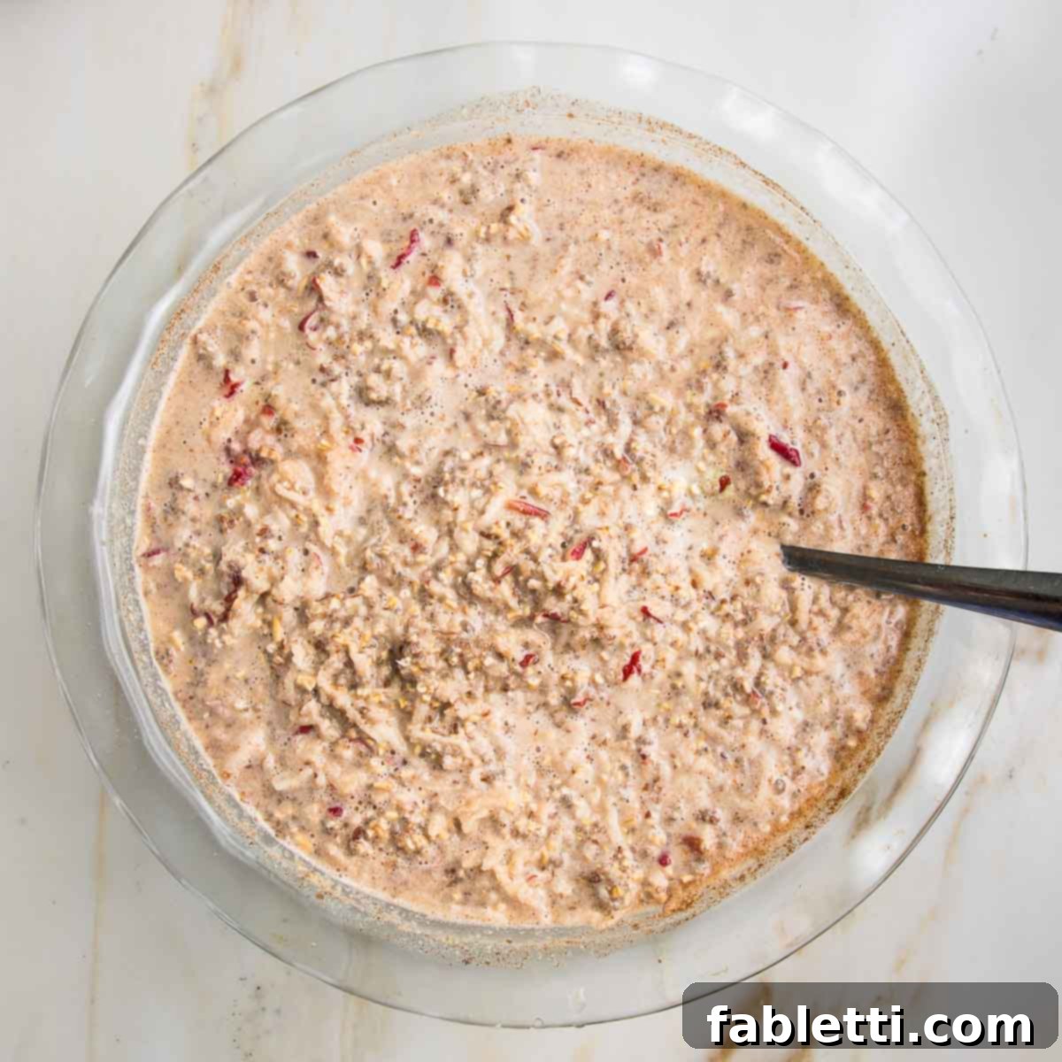 Hearty Baked Steel-Cut Oats 11 Steel cut oats mixed with almond milk, shredded apples, and spices in a glass pie plate.