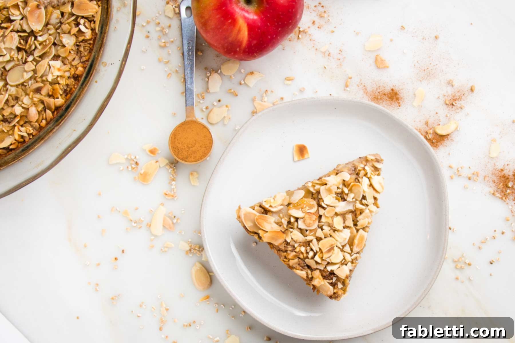 Hearty Baked Steel-Cut Oats 15 Pie shaped slice of baked steel cut oats on a plate. Pie plate with additional oats on the side.