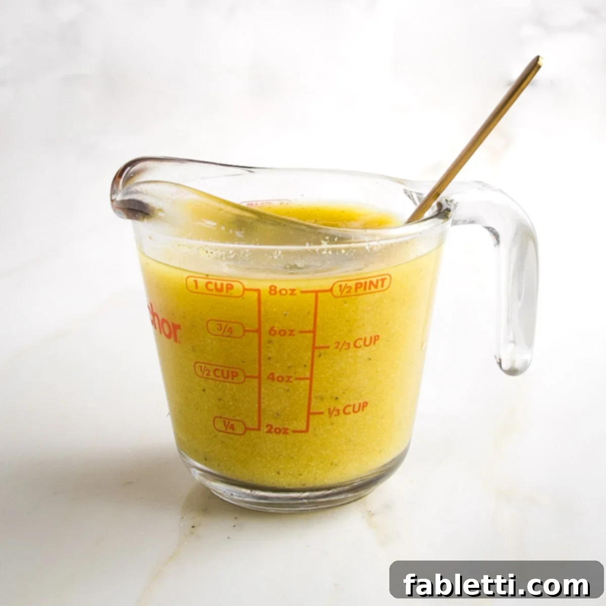 Garden Gold Broth Mix 9 One cup pyrex measuring cup filled with yellowish broth.
