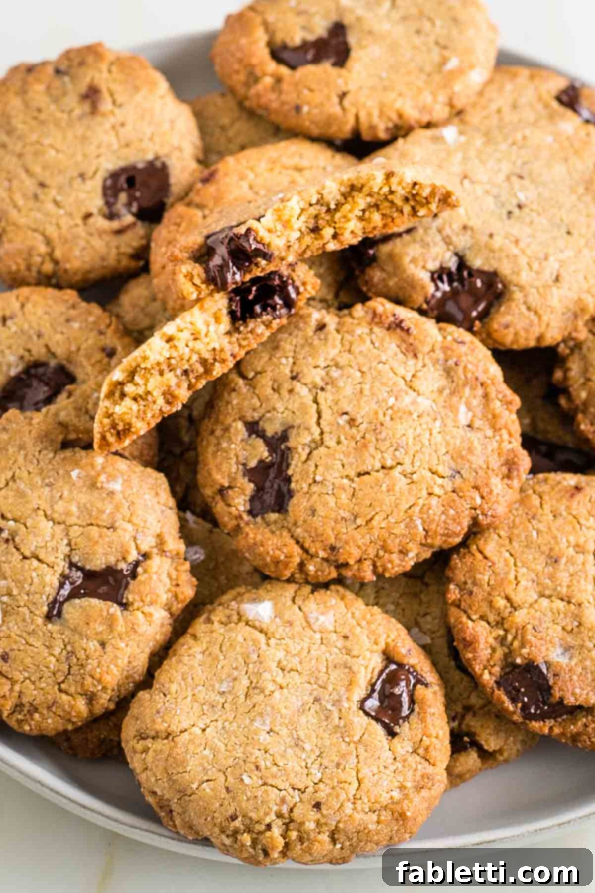 Chewy Vegan Gluten-Free Tahini Chocolate Chip Cookies 2 A plate of chocolate chunk cookies on a white plate.