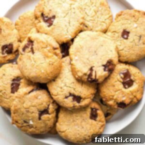 Chewy Vegan Gluten-Free Tahini Chocolate Chip Cookies 16 Plate stacked with chocolate chunk cookies.