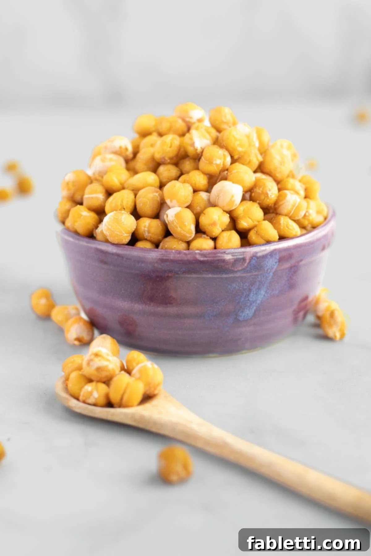 Golden Crispy Chickpea Bites 2 Crunchy roasted chickpeas in a purple bowl. A spoonful close up in front of the bowl.