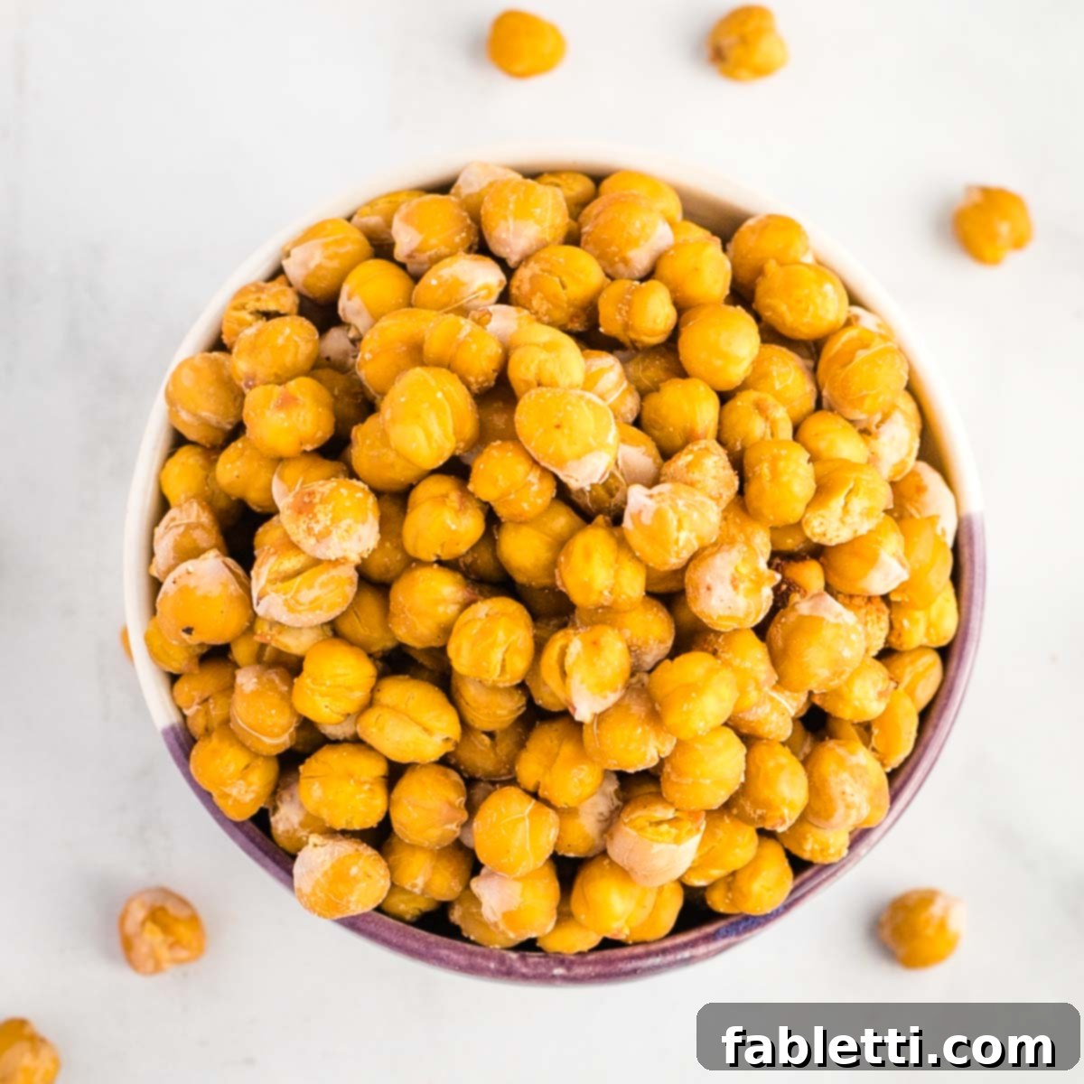 Golden Crispy Chickpea Bites 8 Crispy roasted chickpeas in a glass container with a loose lid.