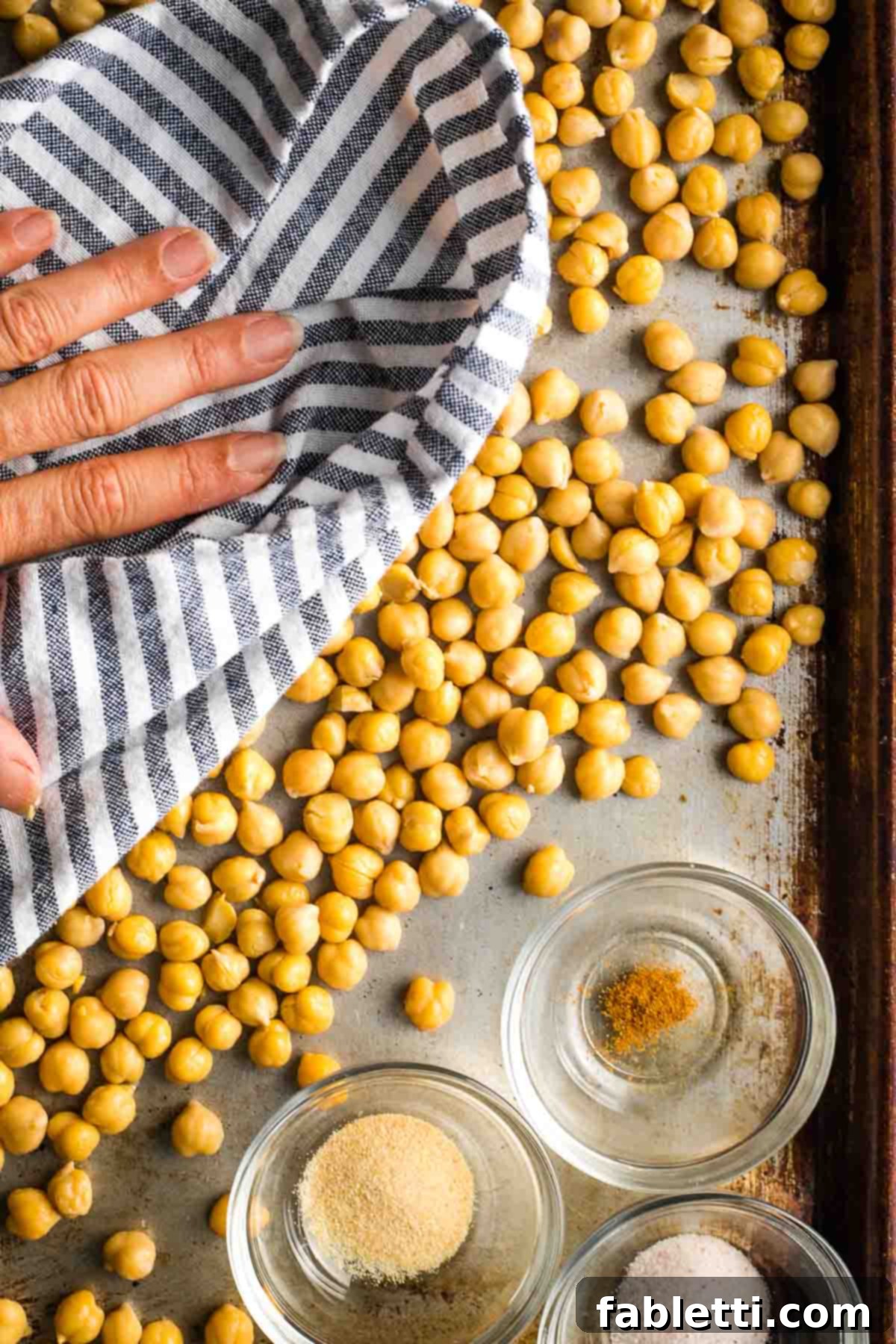 Golden Crispy Chickpea Bites 9 A bowl of roasted chickpeas with a hand reaching for one.