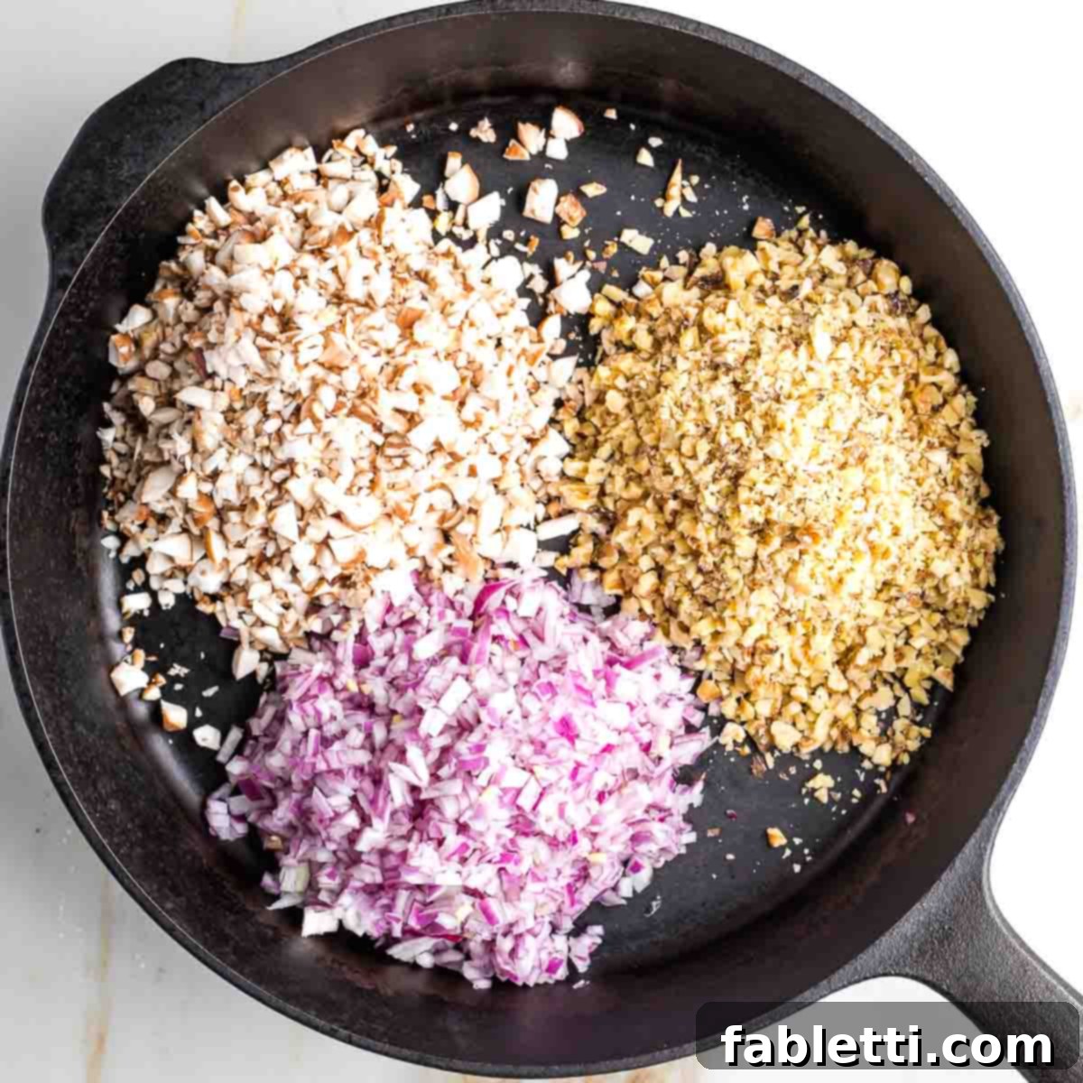 Umami-Packed Vegan Mushroom Lentil Crumble 4 Finely minced red onions, shiitake mushrooms, and walnuts are sautéing in a hot skillet, gently softening and releasing their aromatic flavors, ready for the next stage of cooking.