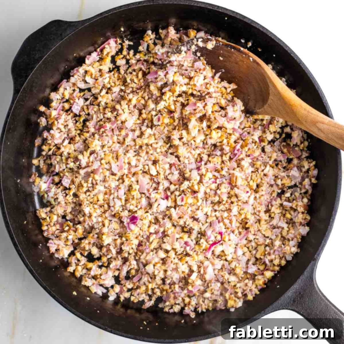 Umami-Packed Vegan Mushroom Lentil Crumble 5 A closer view of the sautéing mixture in the skillet, showing the tender, aromatic vegetables and walnuts starting to brown slightly, indicating they are ready for the addition of spices.