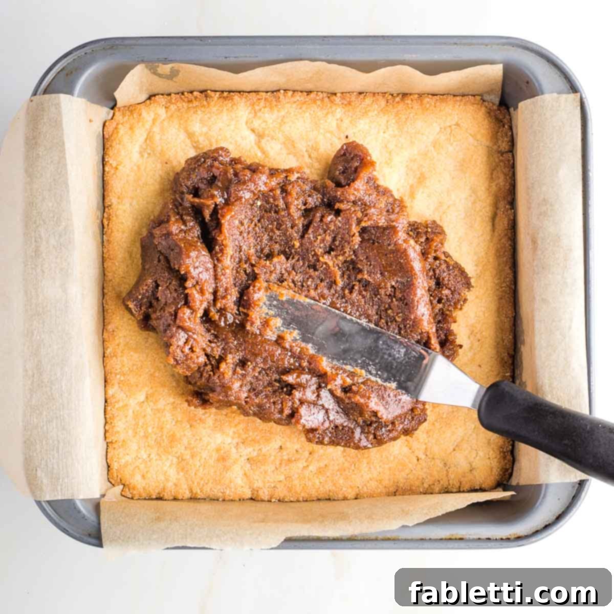 Guilt-Free Homemade Twix Bars 12 A thick layer of rich caramel spread over the golden cookie base in a square baking pan.