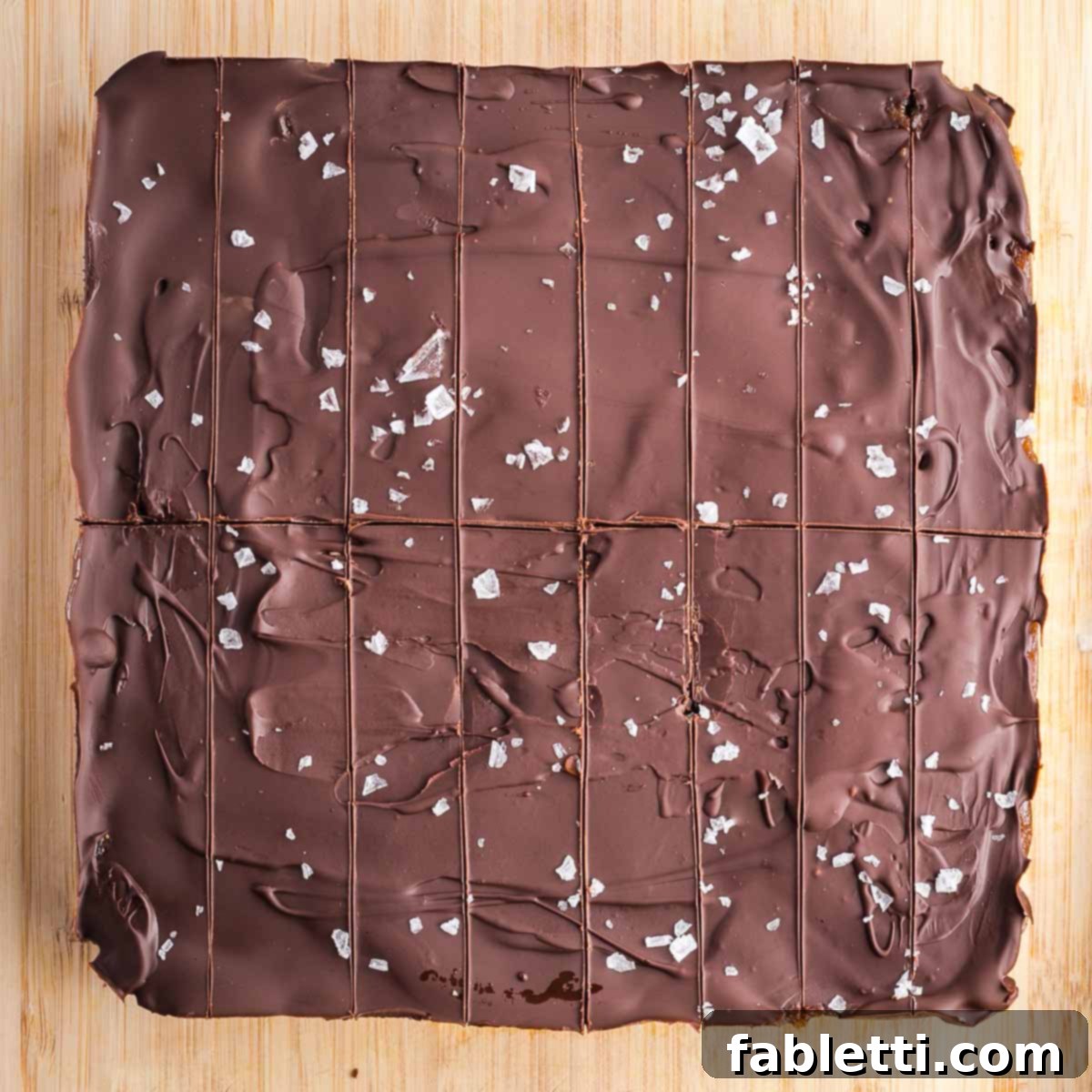 Guilt-Free Homemade Twix Bars 19 A square of chocolate with a horizontal center line and eight parallel vertical lines, indicating precise cuts for individual bars.